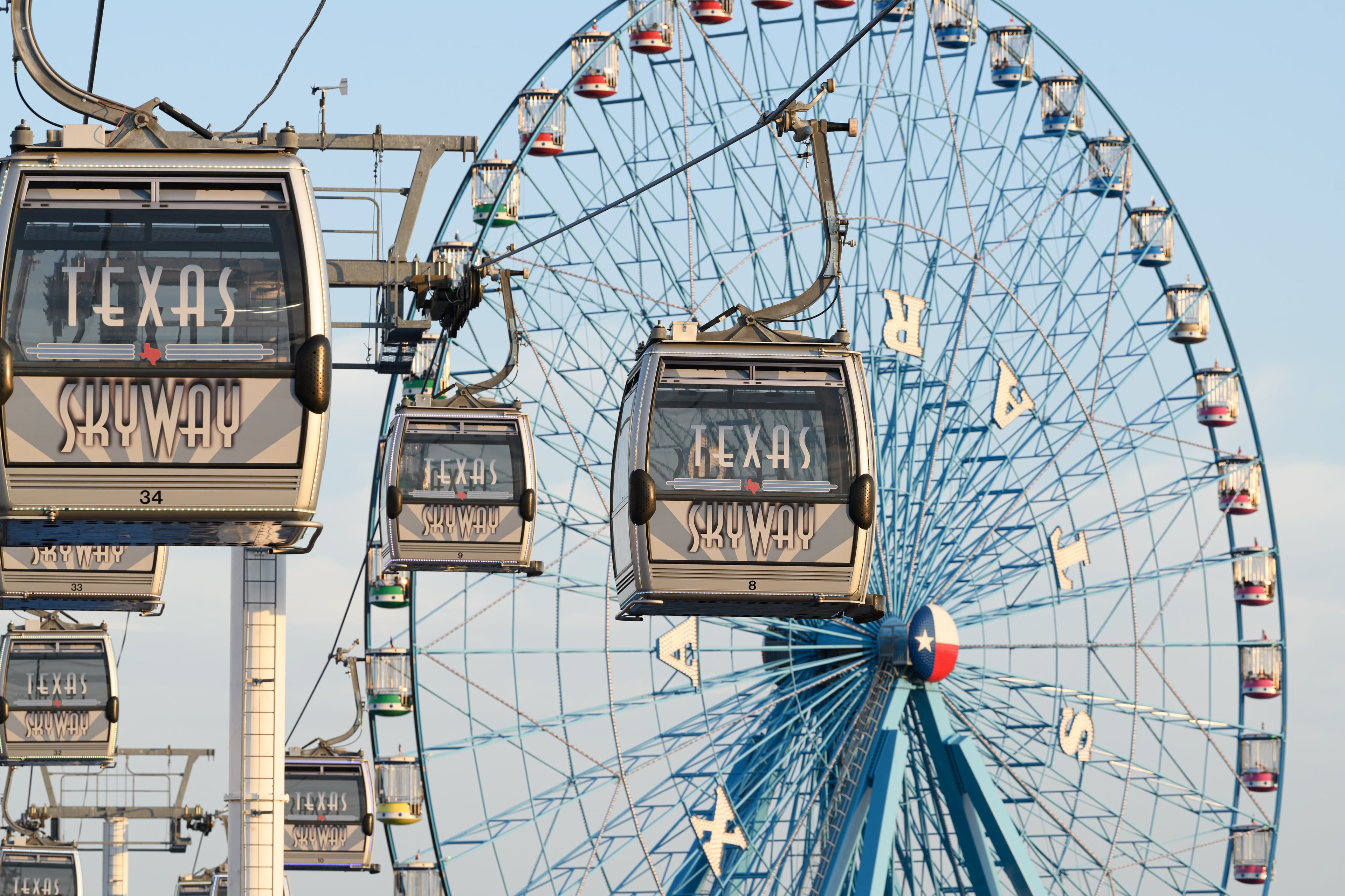 File photo: Texas Skyway gondolas pass in front of the Texas Star Ferris wheel.